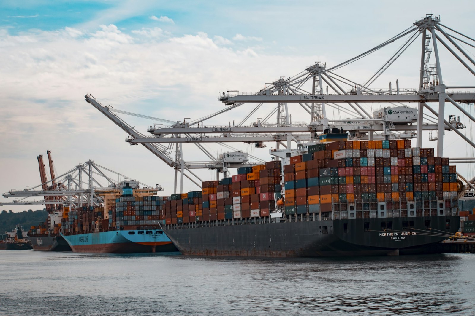 Navios porta-contêineres atracados em terminal portuário durante operação de carga
