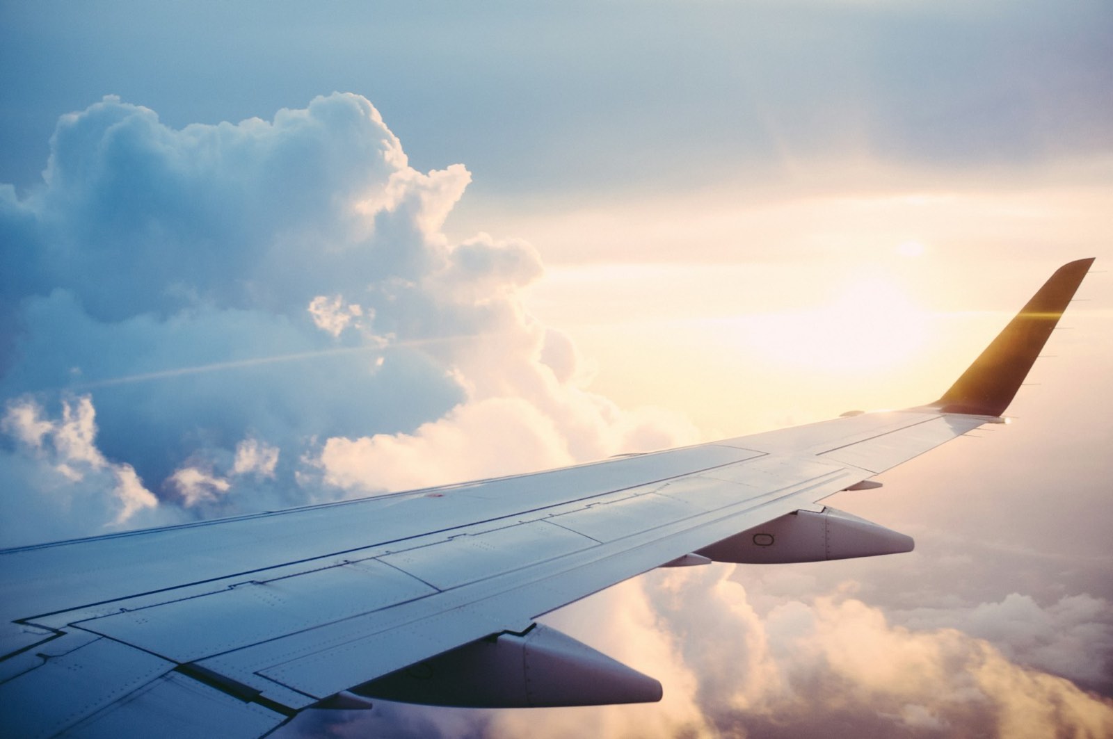 Asa de aeronave sobre camada de nuvens durante voo internacional