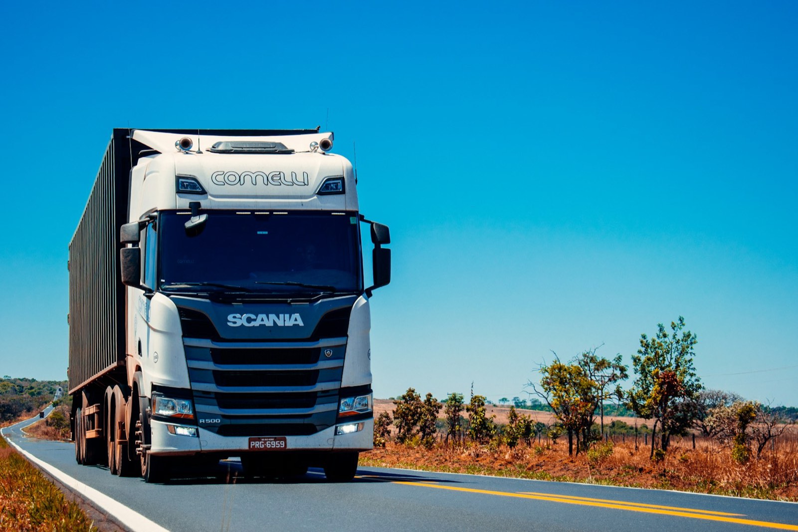Caminhão de carga percorrendo rodovia brasileira em operação de transporte terrestre